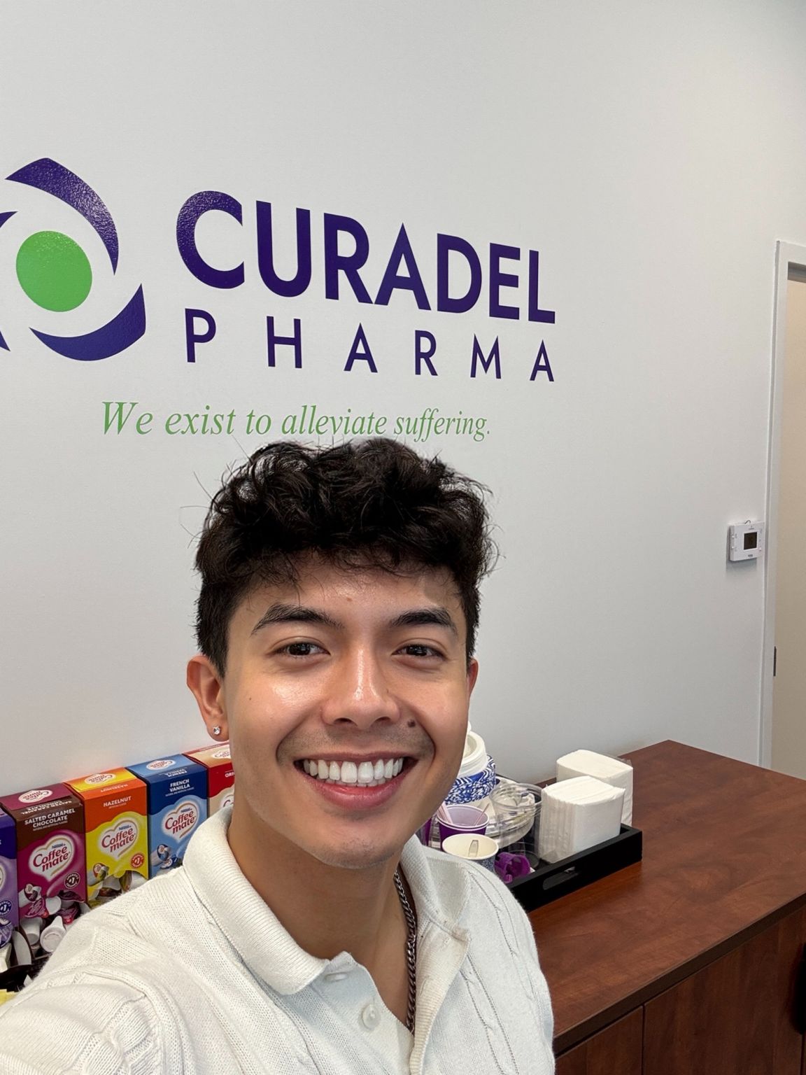 William Joe Brashear smiling in front of the Curadel Pharma logo